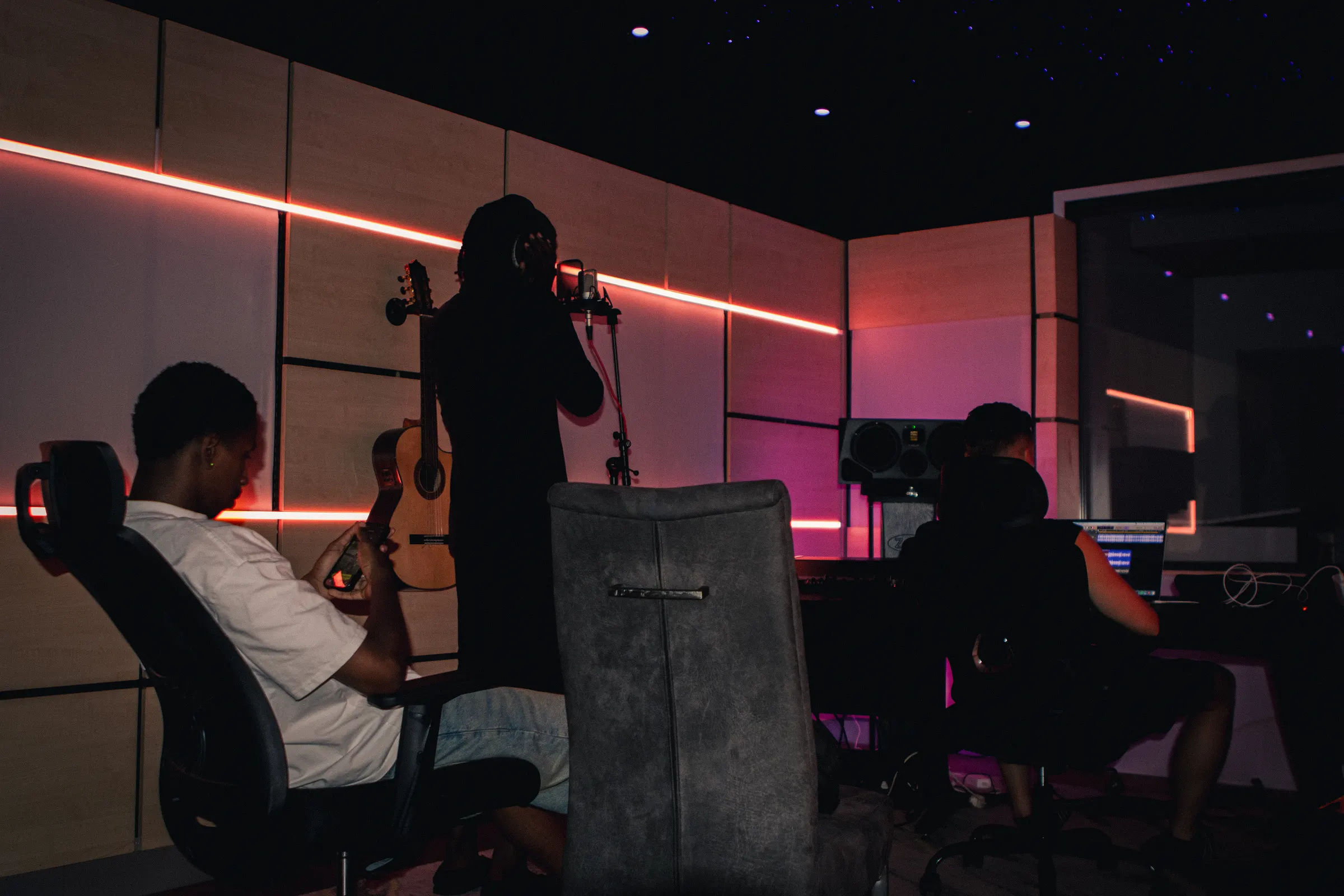 Een volle studio: artiesten en producers tegelijk aan het werk